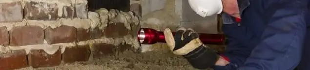 Pest control technician inspecting a crawl space for ant activity and entry points in Salt Lake City, UT