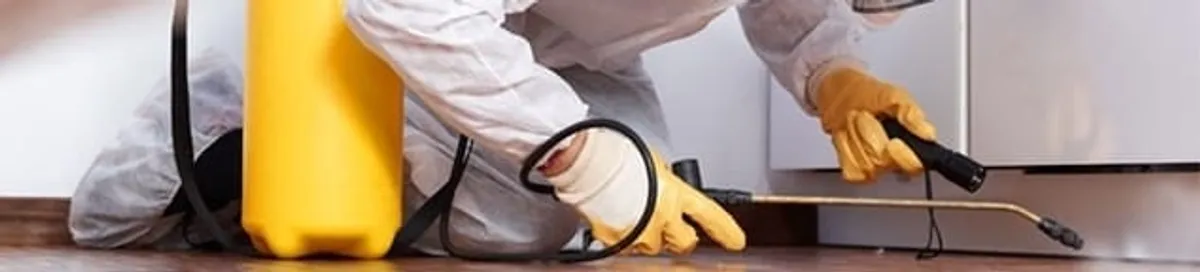 Roach exterminator treating cracks and crevices along kitchen baseboards in Salt Lake City, UT